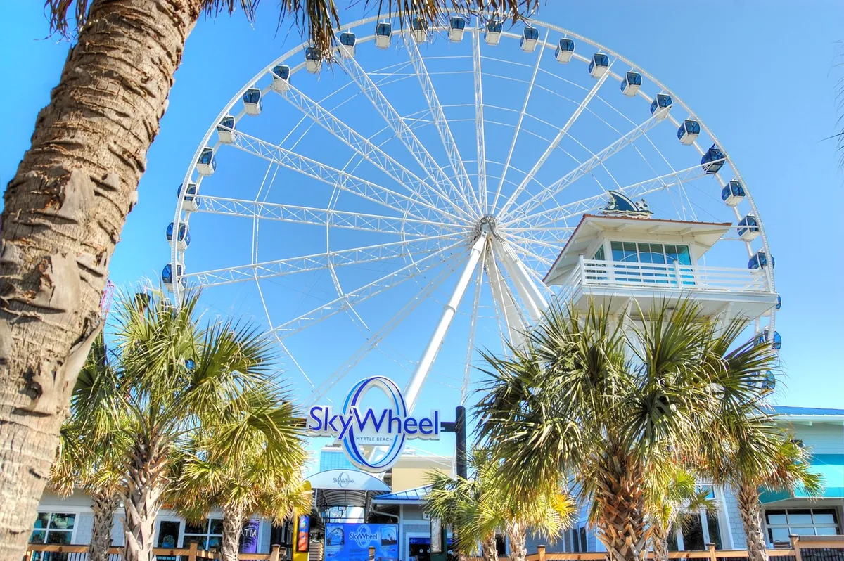 Showcasing the iconic SkyWheel, palm trees, and the lively entrance area, this exterior image captures the excitement and energy of top local attractions just a short drive away. The vibrant mood is perfect for highlighting group adventures.